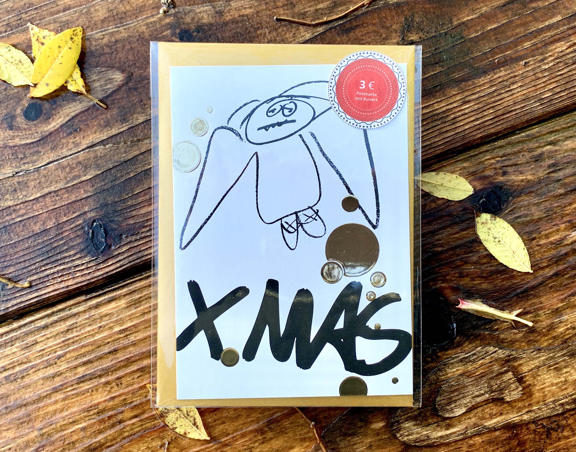 Weihnachtskarte „XMAS...müder Engel“ mit goldenem Kuvert – stilvolle und humorvolle Postkarte für Weihnachten und Engel-Liebhaber. Frontansicht und in Klarsichthülle