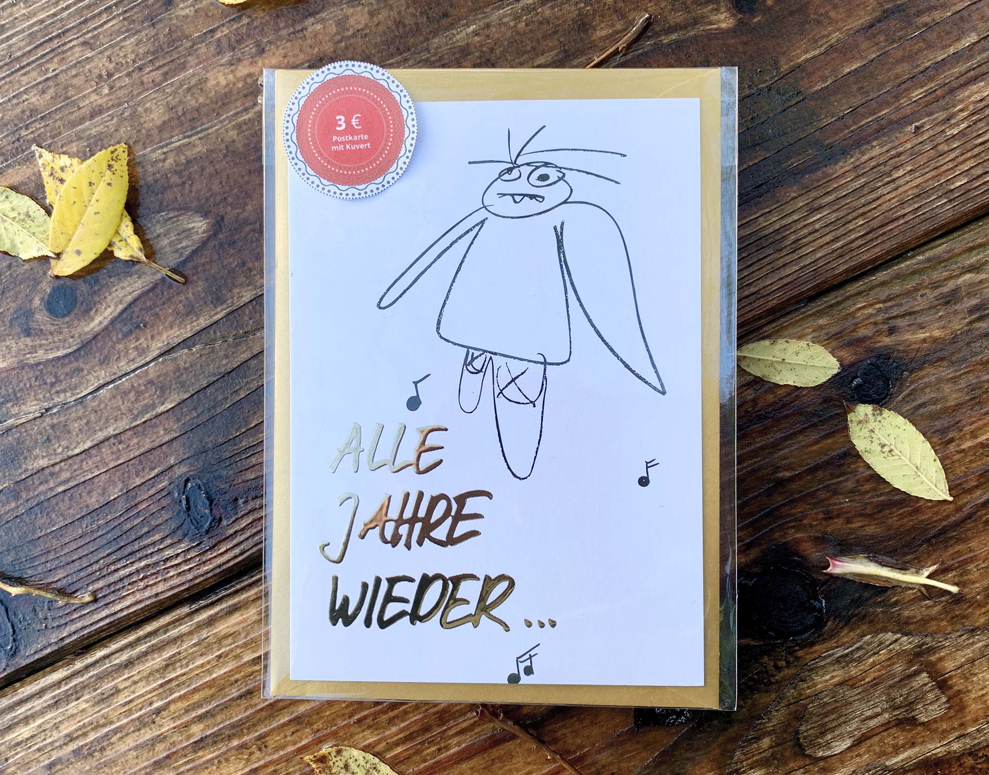 Weihnachtskarte „ ALLE JAHRE WIEDER… müder Engel“ mit goldenem Kuvert – stilvolle und humorvolle Postkarte für Weihnachten und Engel-Liebhaber. Frontansicht und Klarsichthülle
